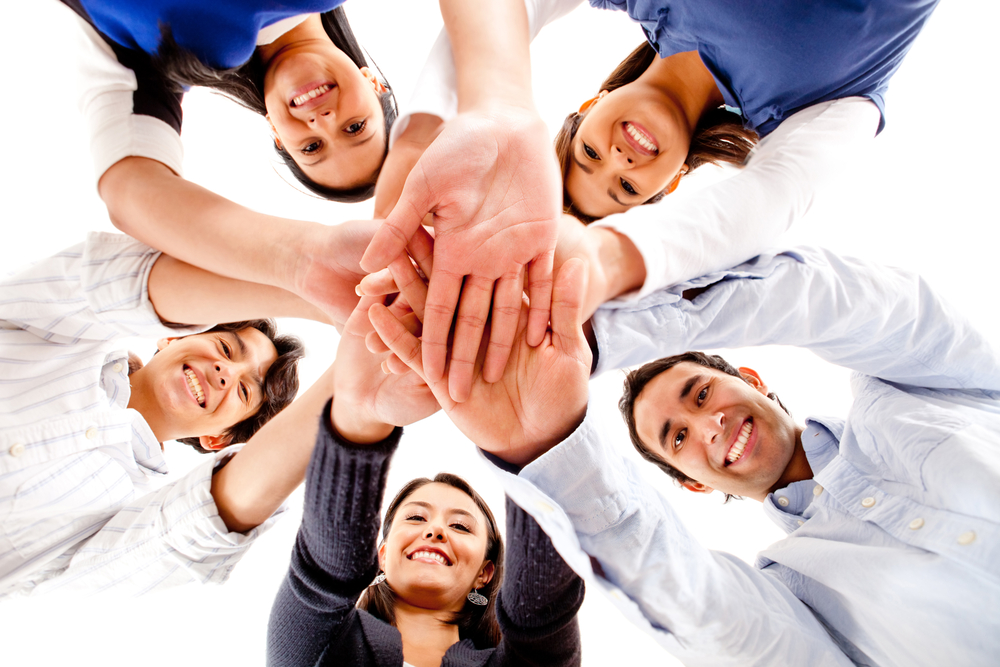 Circle of friends with hands together in the middle - teamwork concepts